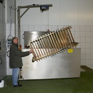 Alu Star-Group - Stikkenwagenreinigungsanlage. Auf dem Foto ist eine Stikkenwagenreinigungsanlage samt verschmutzten Stikkenwagen zu sehen, welcher in die Anlage geführt wird.